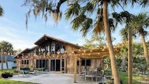 A wooden house with a patio, outdoor seating, and a pergola. - Historical NASA Home (Cape Canaveral)