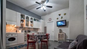 Un espacio habitable compacto con cocina, comedor y sofá.