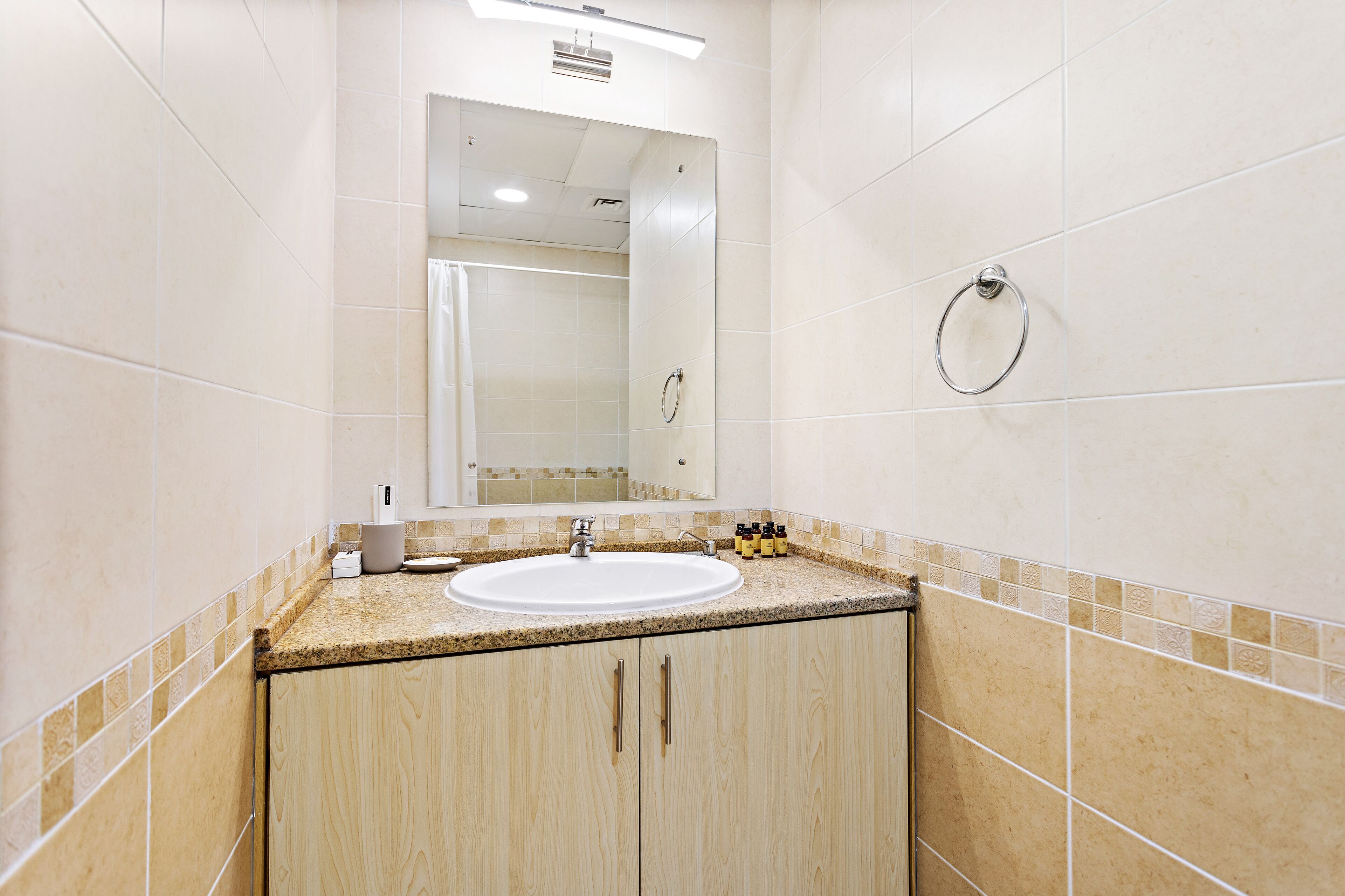 Ein Badezimmer mit Waschbecken, Spiegel und Handtuchhalter.