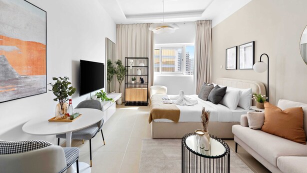 A modern living room with a sofa, coffee table, and dining area. - Silkhaus ASB Tower (Dubai)