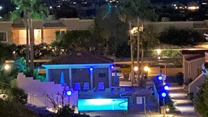 A residential property with a swimming pool, outdoor seating area, and a well-lit pathway. - McDowell Mountain Adventure Condo - Quiet, Heated Pool, Close to Downtown (Fountain Hills)