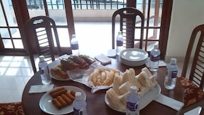 Una mesa de comedor con platos de comida, botellas de agua y sillas.