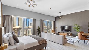 Een moderne hotelkamer met een groot bed, een bank, een eethoek en een televisie.