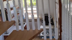 Un escalier avec des balustrades blanches et des marches en bois menant à un palier.