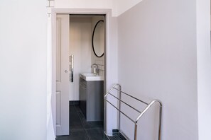 A narrow hallway with a door leading to a bathroom.