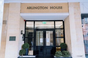 The entrance to Arlington House with a sign above the door, a glass door, and two potted plants on either side. - Stunning Studio Flat with Scenic Views (Bath and North East Somerset)