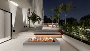 An outdoor patio area with a fire feature, steps leading to a seating area, and a view of palm trees and a building in the background. - AMA VILLAS - Luxury Collection -  **BRAND NEW ****35% DISCOUNT AVAILABLE (Rose Hall)