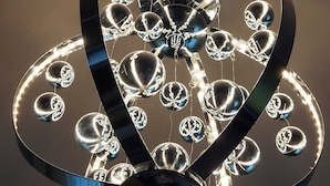 A ceiling with a decorative, reflective, metallic structure featuring spherical elements and curved lines. - Captivating 1-bed Apartment in Blackpool (Blackpool)
