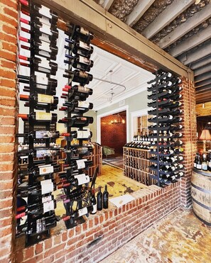 A wine cellar with multiple wine racks filled with bottles. - The NuWray Hotel & Carriage House (Burnsville)