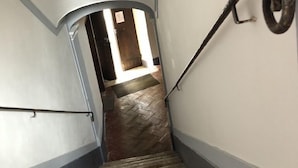A staircase with a metal handrail and a herringbone-patterned floor. - DIMOR'A'   ROOMS (Pitigliano)