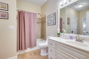 Een badkamer met douche, toilet, wastafel en badkamerkast.