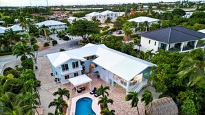 Un resort con piscina, varias edificaciones y palmeras.