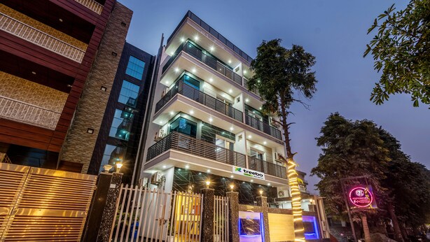 A multi-story hotel with a modern facade, illuminated windows, and a gated entrance. - Treebo Expo Mart Inn, Greater Noida (Greater Noida)