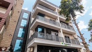 A multi-story building with a modern design, featuring balconies and large windows. - Treebo Expo Mart Inn, Greater Noida (Greater Noida)