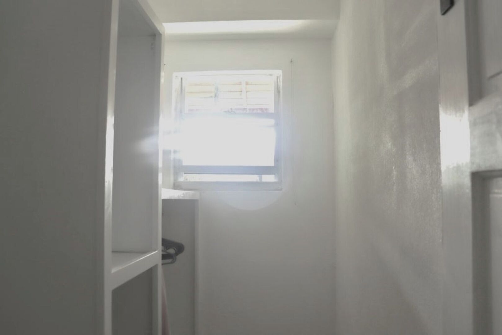 A narrow hallway with a window at the end.