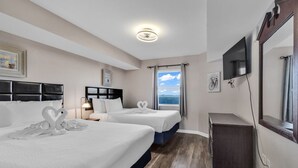 A hotel room with two beds, a TV, a mirror, and a window with a view. - Ocean View 1BR Condo with Private Balcony (Myrtle Beach)