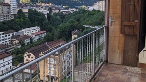 Un balcon avec vue sur la ville et les montagnes.
