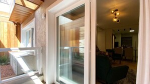 A modern living room with a sliding glass door leading to a balcony.