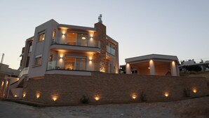 Un edificio moderno de varios pisos con balcones e iluminación exterior.