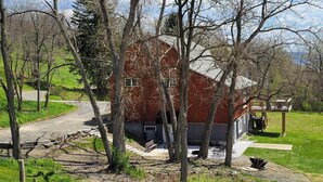 Eine rustikale Holzhütte mit einer Holzterrasse und einer kleinen Sitzgelegenheit im Freien.