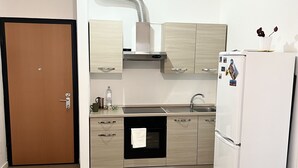 Eine moderne Küche mit Einbauofen, Kühlschrank und Spüle.