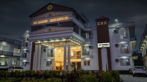A multi-story hotel with a grand entrance, a sign for CRS, and a Treebo logo indicating a spa and restaurant. - Treebo Siri Ambari Resorts (Piriyapatna)