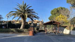 A paved area with a palm tree, a gazebo, and a street lamp. - Apartamento Para Parejas Reformado con Piscina y Wifi (Palafrugell)