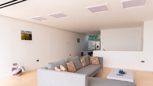 Ein modernes Wohnzimmer mit einem grauen Ecksofa, einem Couchtisch und einem kleinen Teppich.
