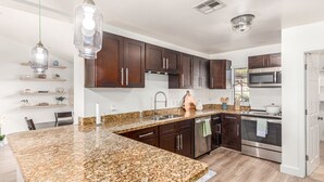 A modern kitchen with granite countertops, stainless steel appliances, and wooden cabinets. - Serenity in the heart of Phoenix's Camelback East/Biltmore 3 bedrooms 2 baths  (Phoenix)