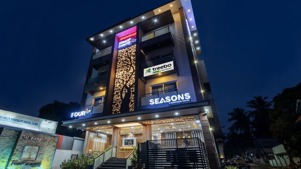 A multi-story hotel with a modern design, featuring a prominent sign for 'Seasons Boutique Hotel' and a 'Treebo' sign indicating a nearby restaurant. - Treebo Four Seasons, Near Mysore Palace (Mysore)