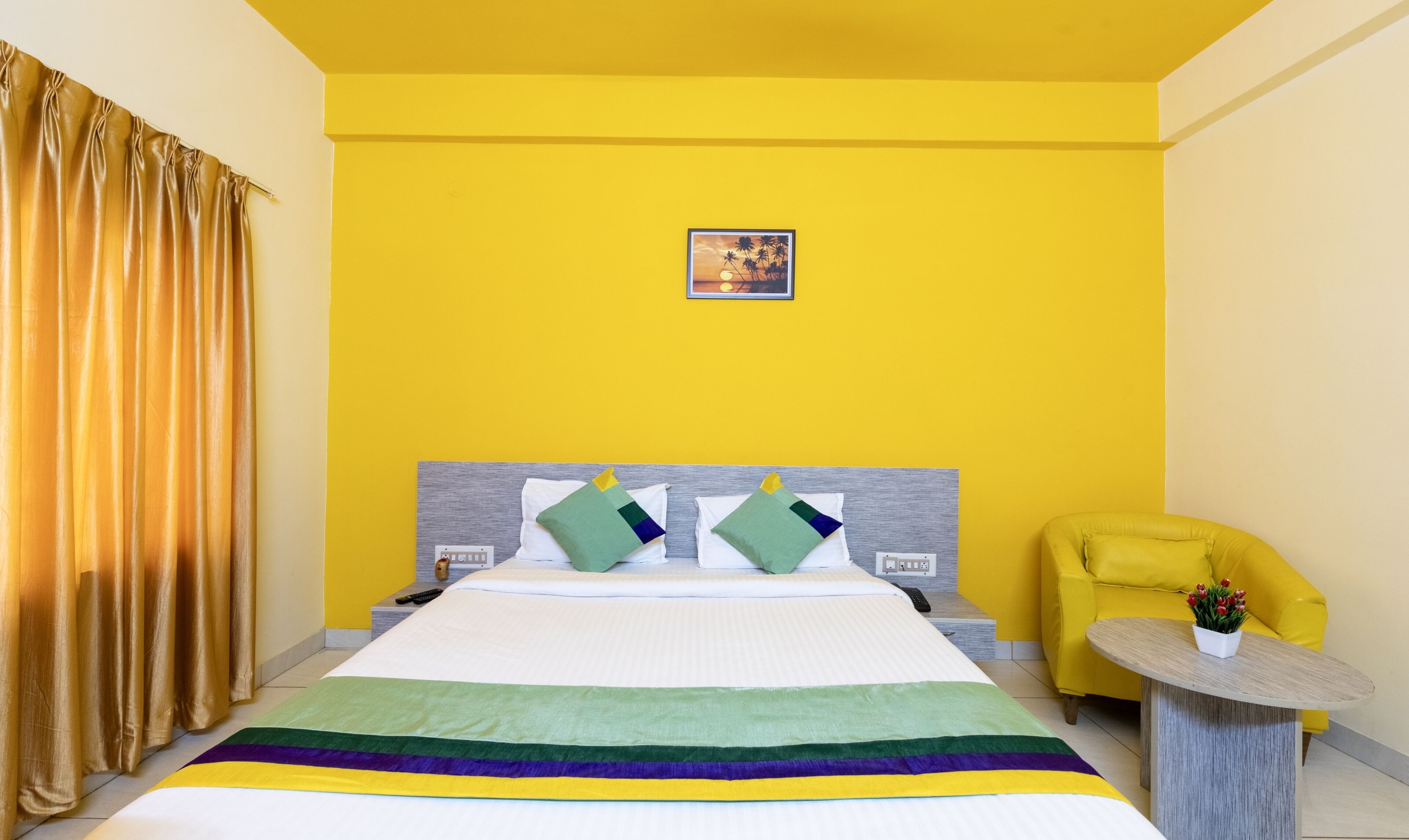 Una camera d'albergo con un letto, un comodino, una sedia e un tavolino.