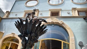 A building with a large fountain sculpture in front.