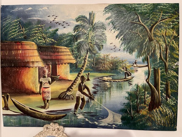 A traditional village scene with huts, a river, and people engaged in daily activities.