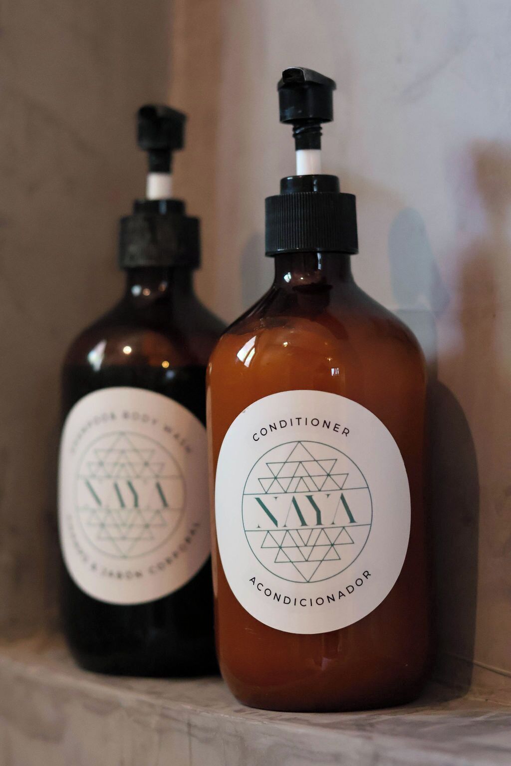 Two bottles of body wash with labels, one in front and one in the background.