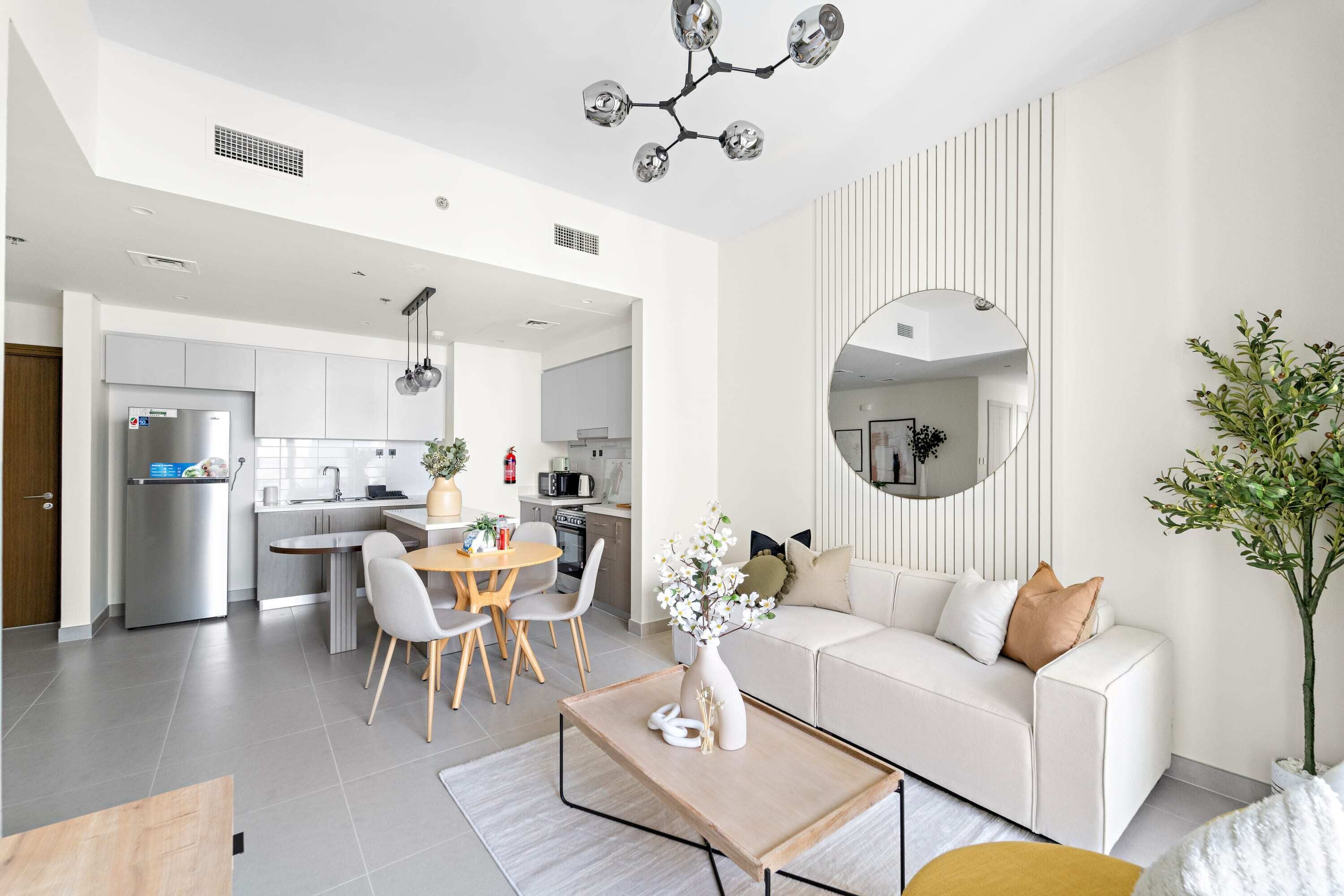 A modern living room with a sofa, coffee table, and dining area.