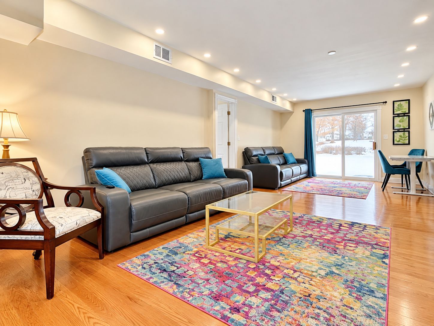 Una sala de estar moderna con un sofá, un sillón, una mesa de centro y una alfombra colorida.