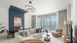 A modern living room with a sectional sofa, a round coffee table, a TV, and a dining area with a table and chairs. - Silkhaus Julphar Tower, Al Reem Abu Dhabi (Abu Dhabi)
