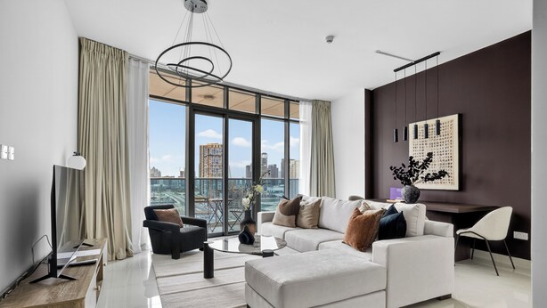 A modern living room with a large window, a sofa, a coffee table, and a TV. - Silkhaus Julphar Tower, Al Reem Abu Dhabi (Abu Dhabi)