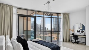 A modern hotel room with a large bed, a desk, and a view of a cityscape through floor-to-ceiling windows. - Silkhaus Julphar Tower, Al Reem Abu Dhabi (Abu Dhabi)
