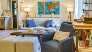 Un salon comprenant un canapé, des fauteuils, une table basse et une carte du monde accrochée au mur.