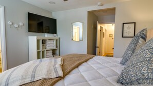 Une chambre à coucher avec un lit, une télévision, un miroir et une armoire.