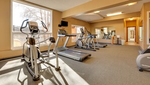 Ein Fitnessstudio mit Laufbändern, Crosstrainern und einem Fahrradergometer.