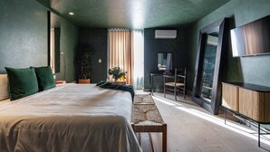 Un dormitorio moderno con una cama grande, un escritorio pequeño y una televisión.