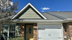 Een woonhuis met garage, een voordeur met ruit en een gevel van baksteen.
