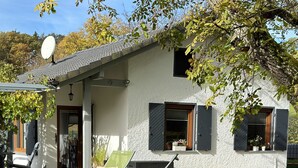 Ett modernt hus med vit fasad, en satellitparabol och en välskött gräsmatta.