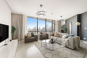 A modern living room with a large window, a sofa, a coffee table, and a TV.