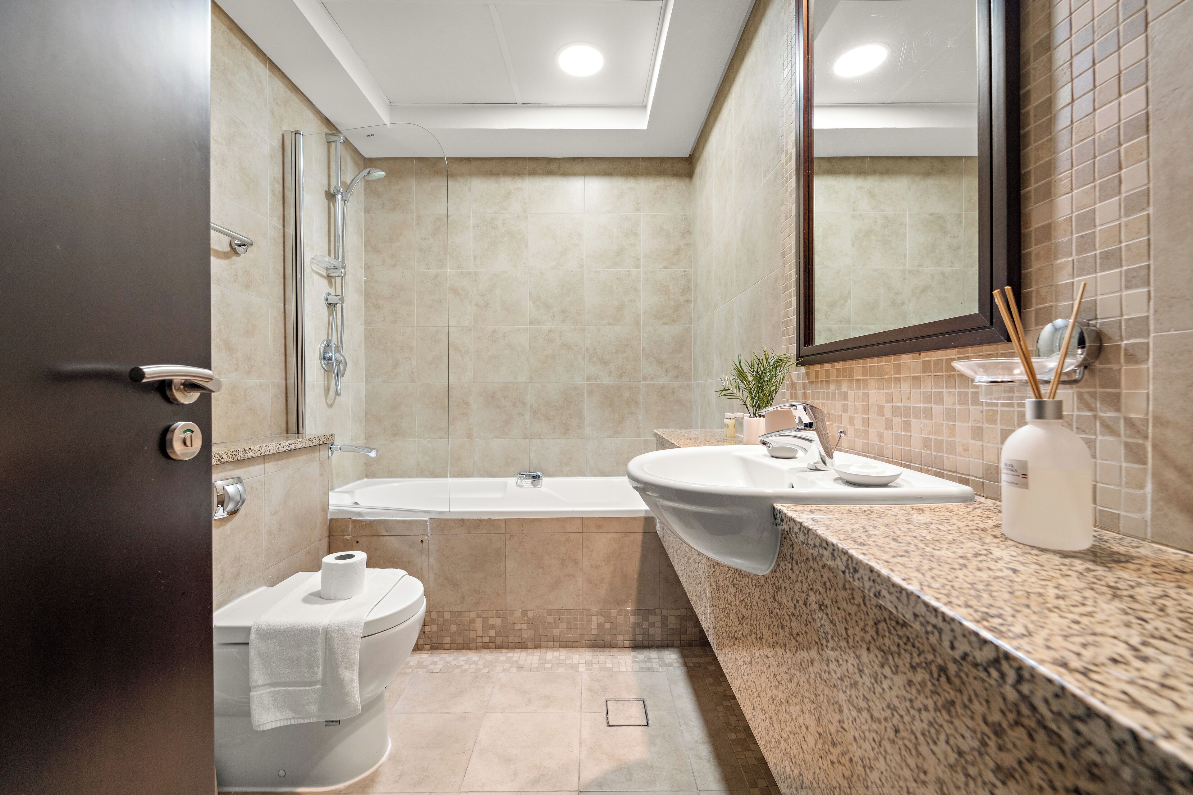 A modern bathroom with a bathtub, a sink, and a toilet.