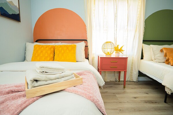 Un dormitorio con cama, mesita de noche y mesilla auxiliar.