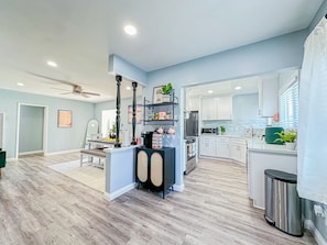 A modern kitchen with white cabinets, a stainless steel refrigerator, and a microwave.