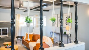 A modern living room with a sofa, a coffee table, and hanging planters.